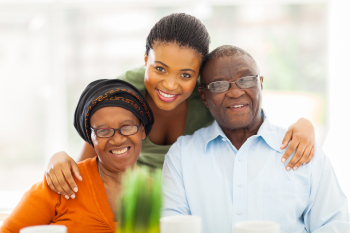 caregiver and senior couple smiling