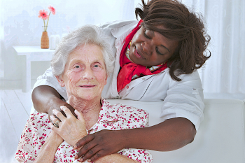 caregiver hugging senior woman